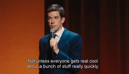 A man in a suit (John Mulaney) on a stage with a blank/serious expression on his face. The words "Not unless everyone gets real cool about a bunch of stuff really quickly." are displayed.