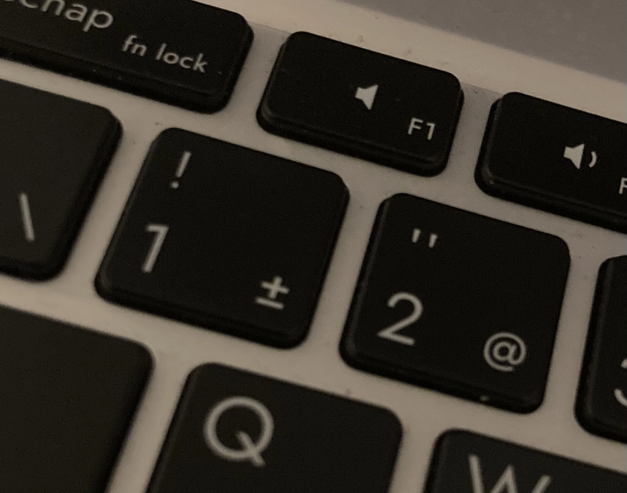 Picture of a canadian french QWERTY keyboard, centered on the 1 and 2 keys. The 1 key as the exclamation mark above the 1, and the 2 key has the quotation mark above the 2.