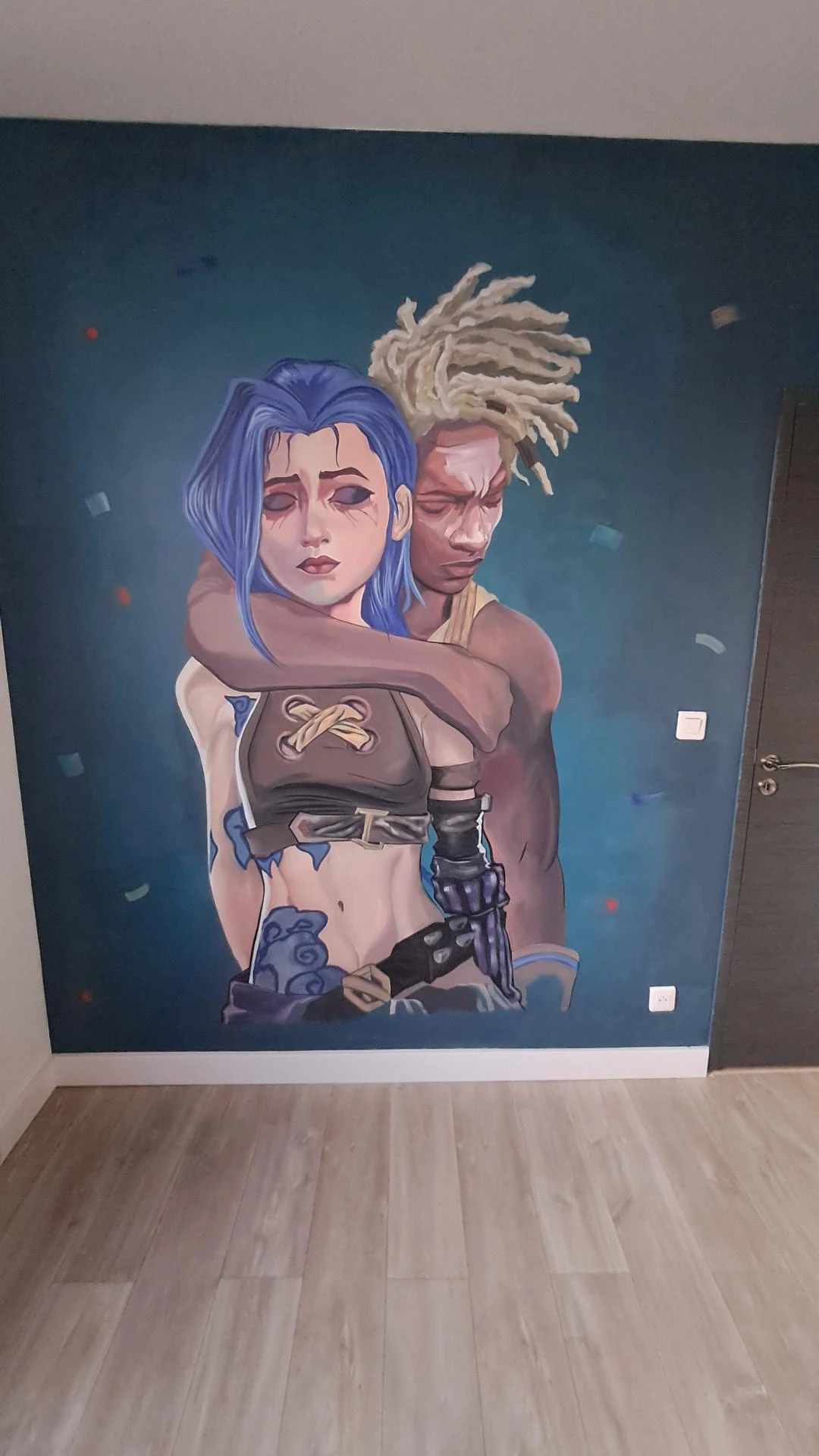 Photo de mon mur avec Jinx et Ekko peint-es sur un fond vert foncé avec quelques confettis. La scène est triste. Ekko est derrière Jinx, un bras autour d'elle, la tête contre la sienne, les yeux fermés, alors qu'elle est les bras ballants, yeux fermés avec le fard à paupière qui a coulé.