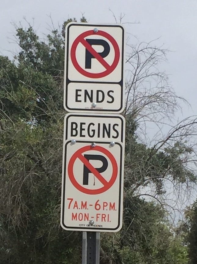 American "No Parking" sign, showing a backslash in the "no" symbol