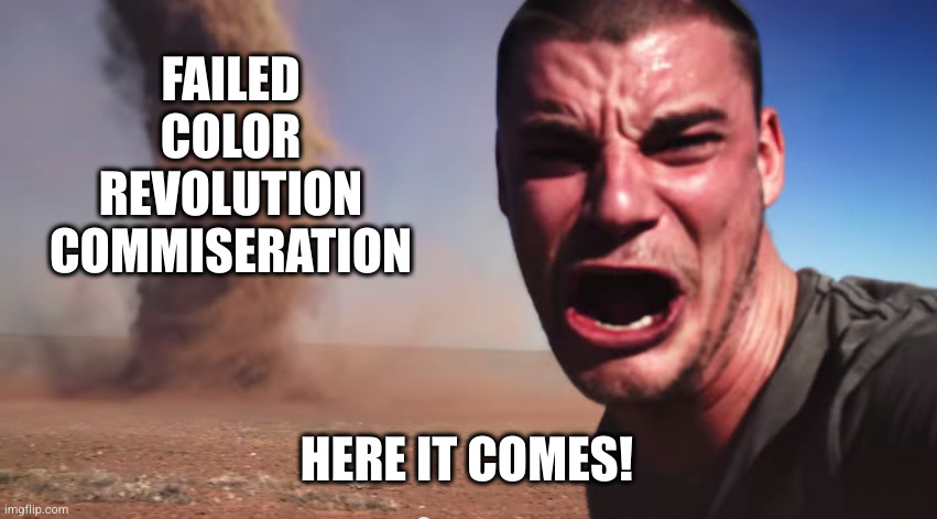 Here it comes meme. On the right, a young white man, turning left, yelling into the frame with squinted eyes: "Here it comes!" On the left, a dust tornado labelled "failed color revolution commiseration."