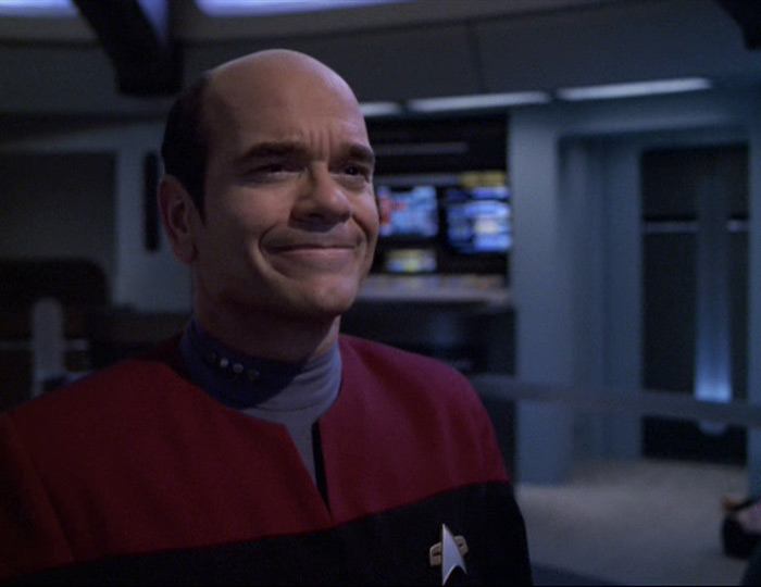 A screencap from "Tinker Tenor Doctor Spy" featuring the EMH in a red uniform and captain's pips.