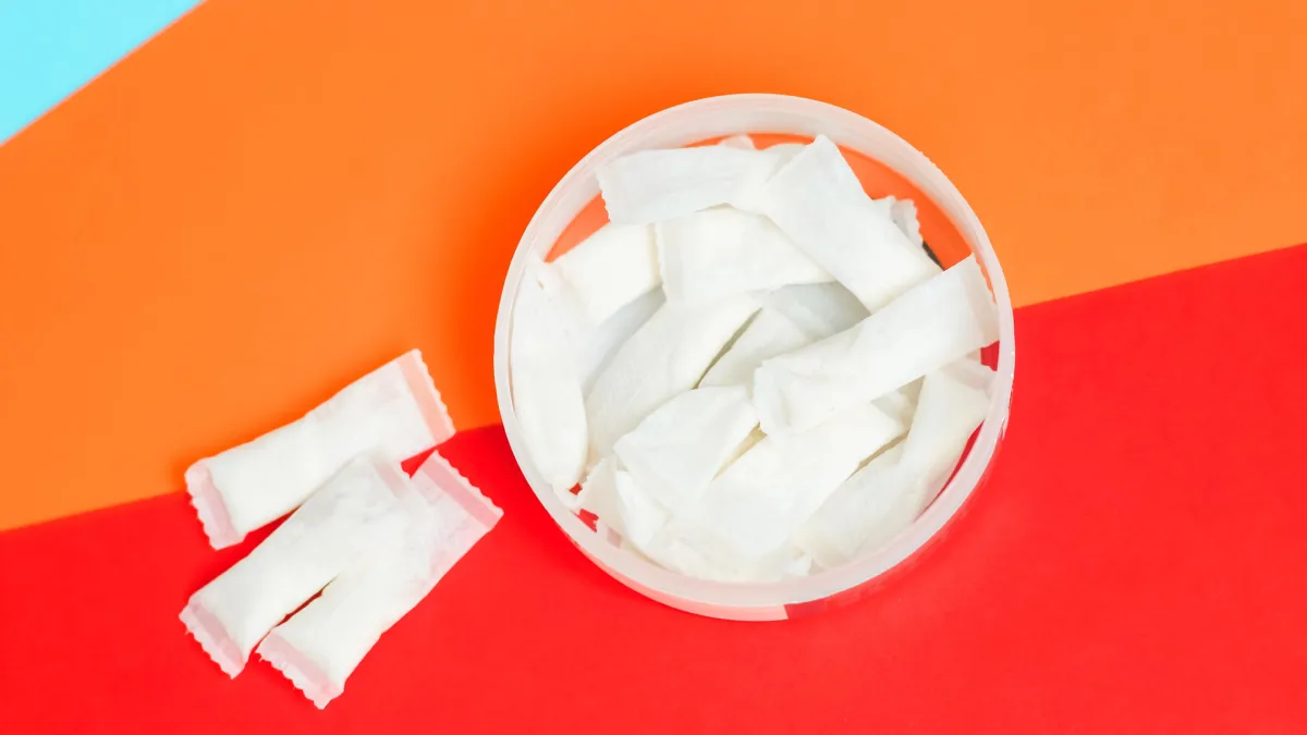 an open round container with small white pouches